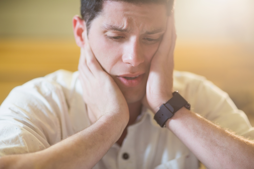 Anxious male student during exam in lecture hall